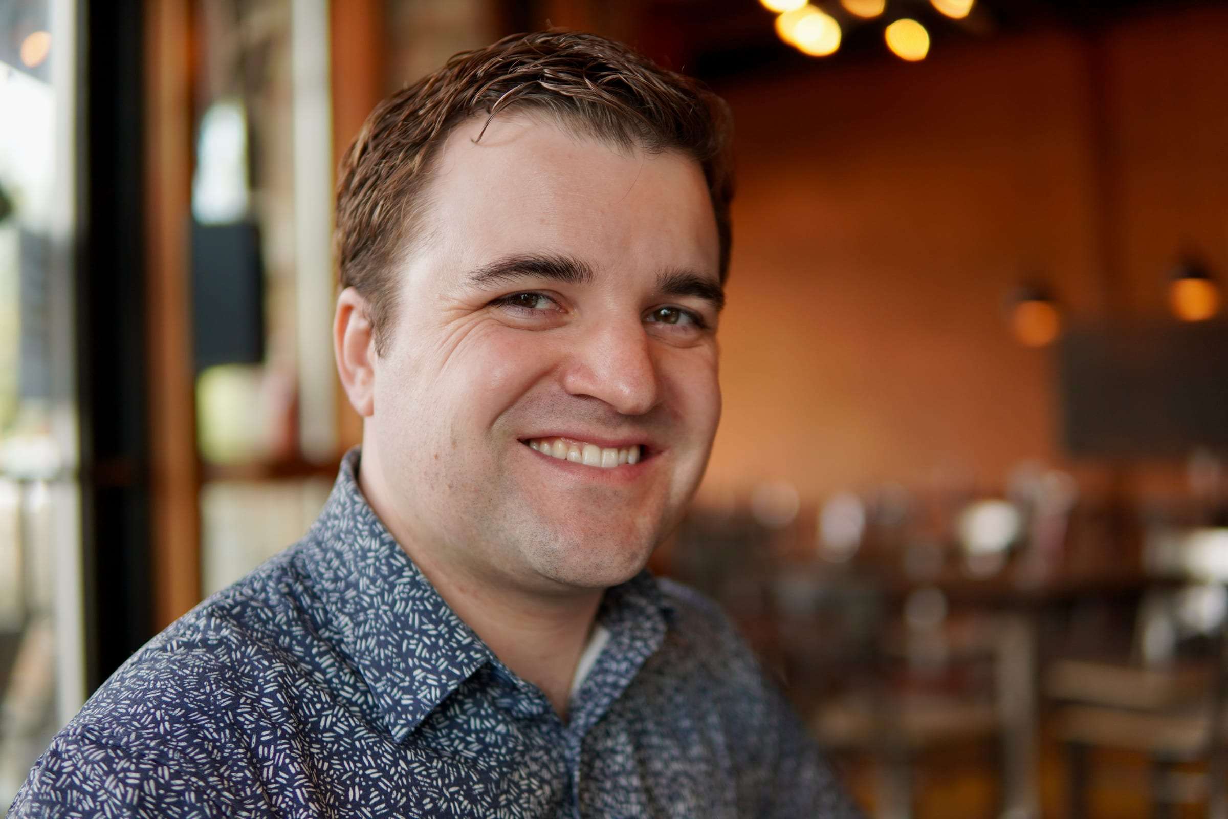 Brett Wharton seated in a warm restaurant interior