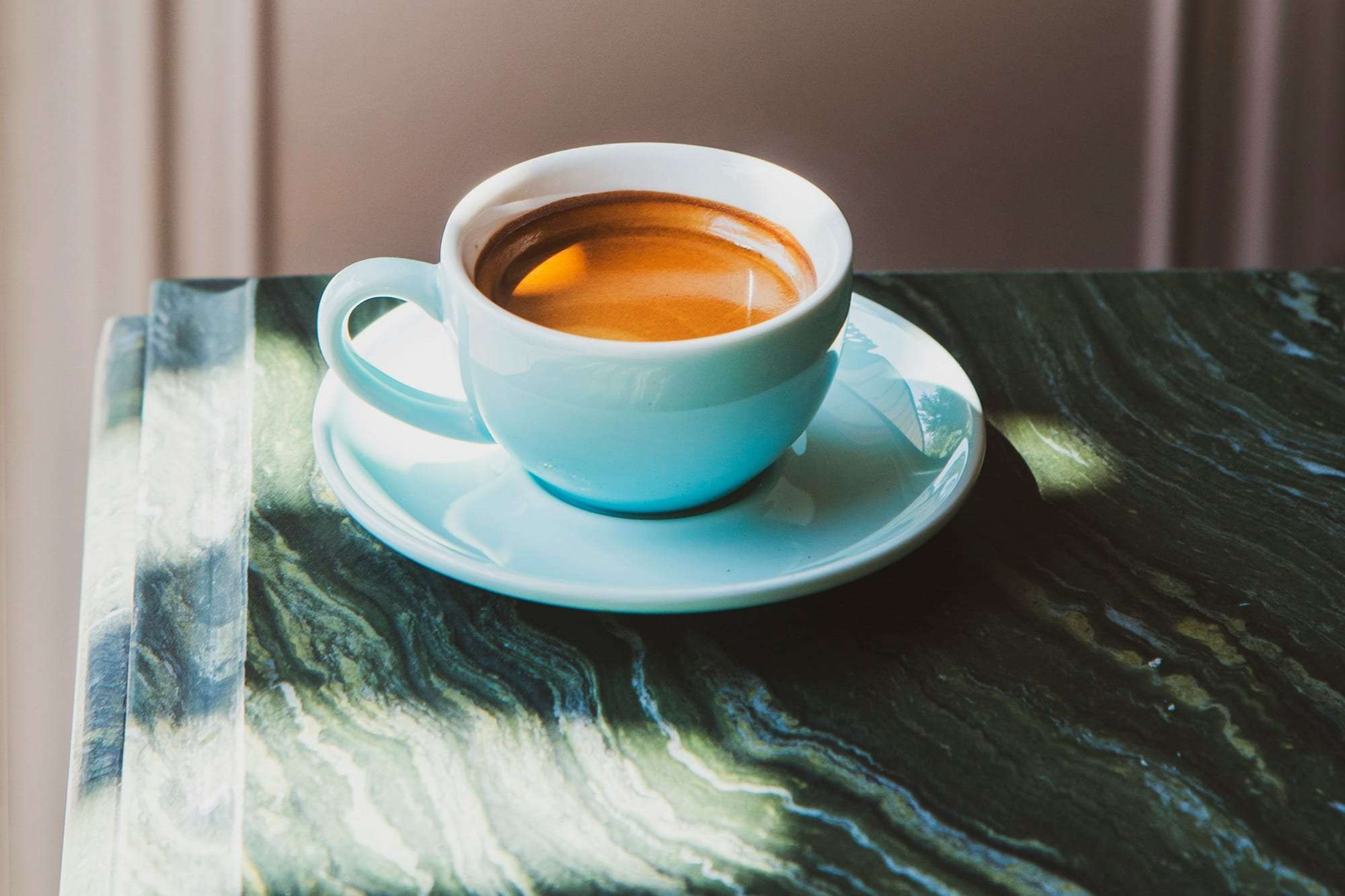 An espresso cup on a green marble table