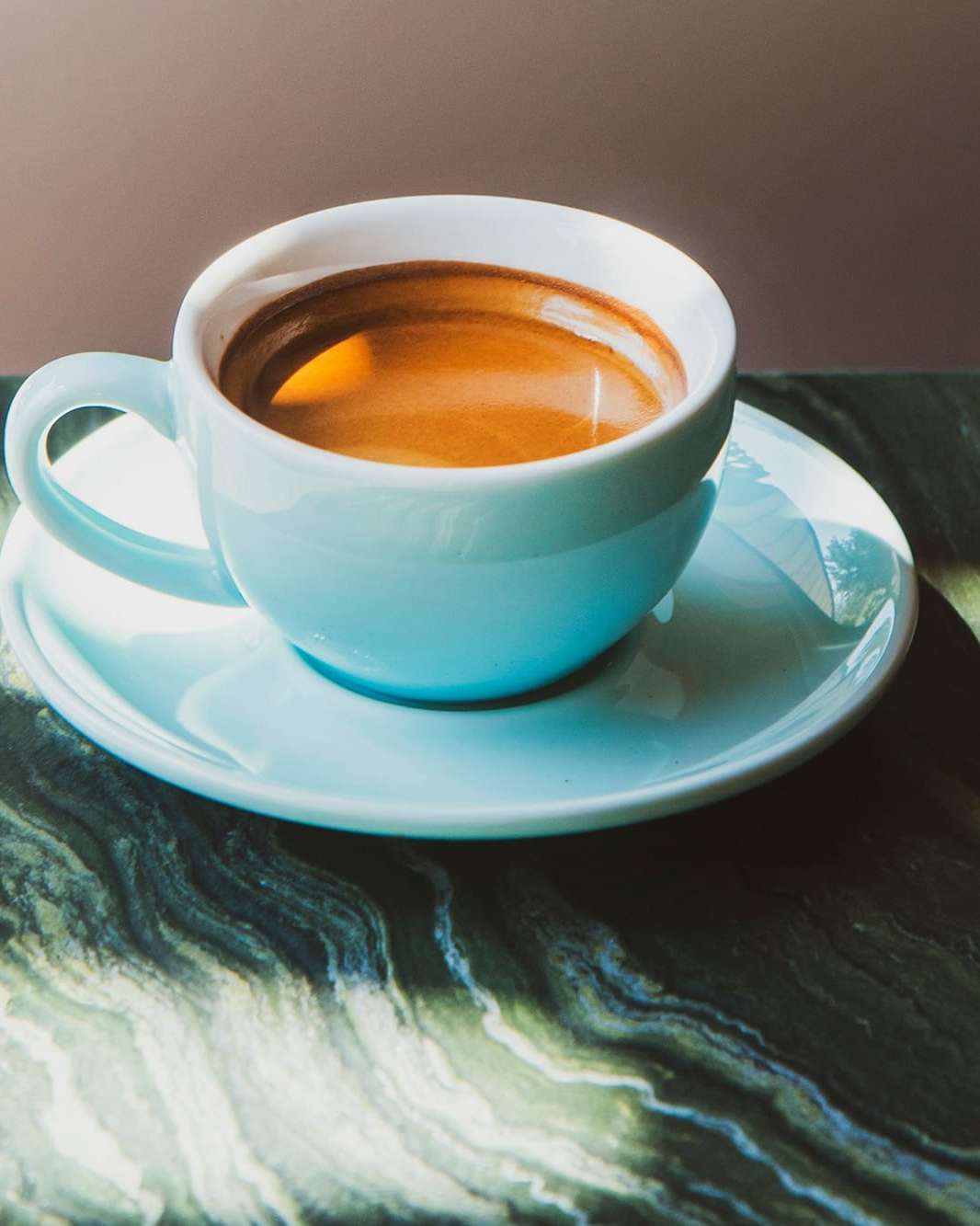 An espresso cup on a green marble table