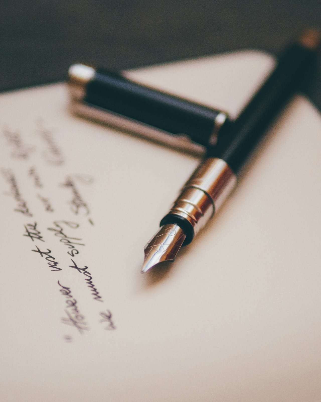 A fountain pen resting on a handwritten letter
