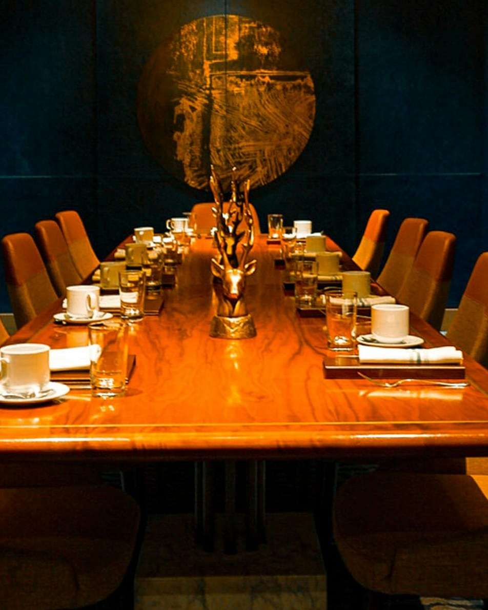 A private dining room with amber chairs around a long table