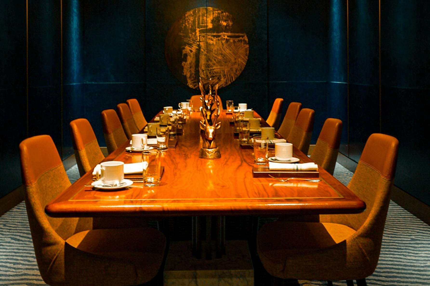 A private dining room with amber chairs around a long table
