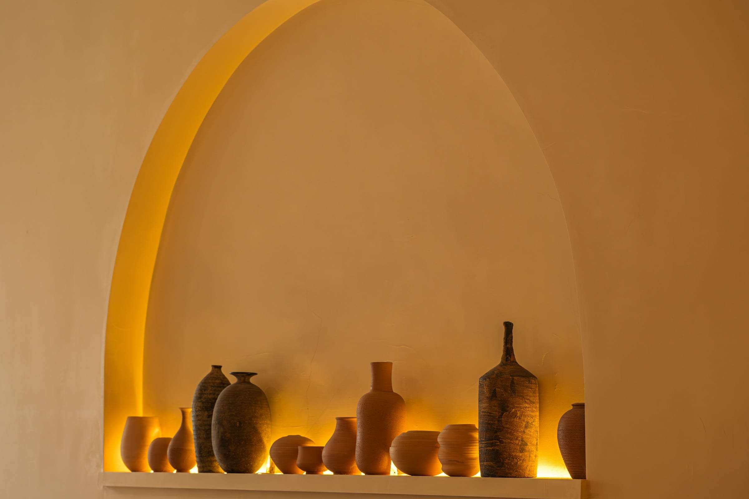 Ceramic vessels arranged in an arched plaster niche