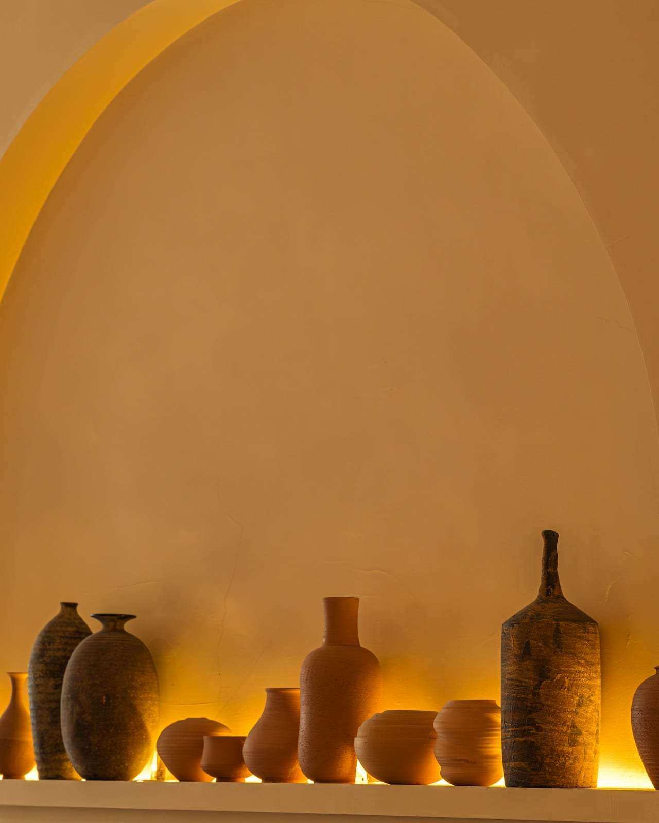 Ceramic vessels arranged in an arched plaster niche