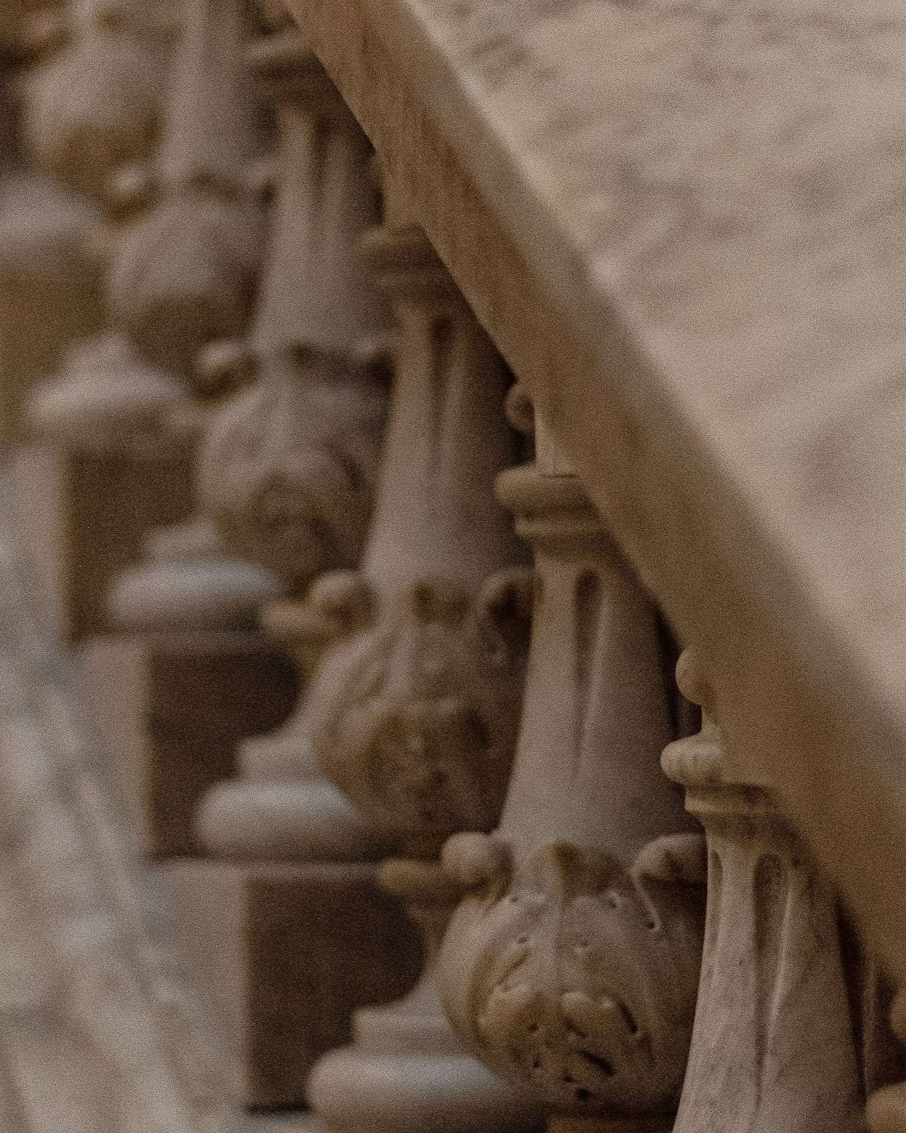 A marble staircase with a curving balustrade, seen rising toward the light