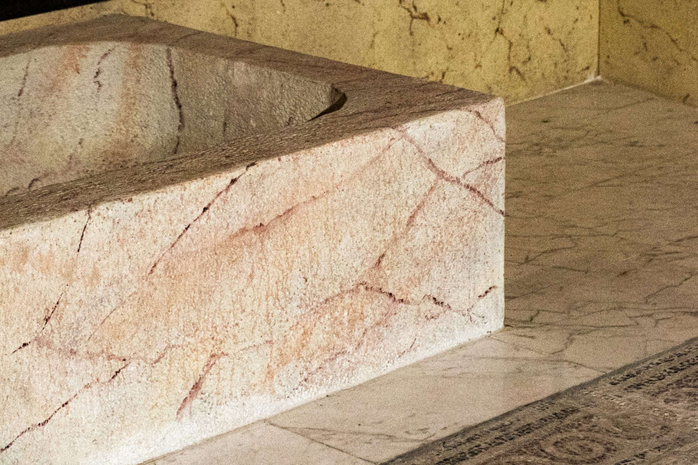 A marble bath set against stone walls