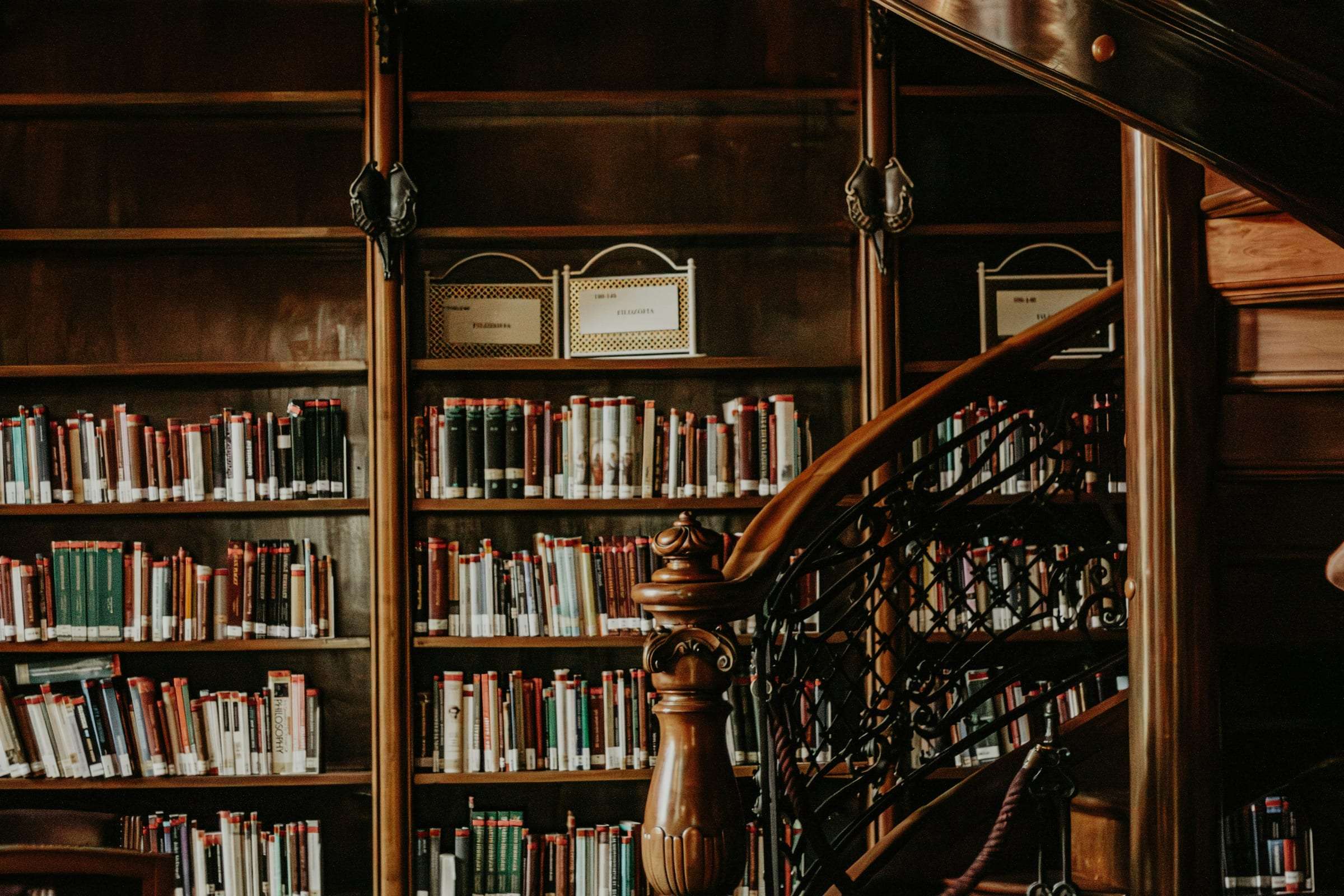 An old private library with a wooden staircase and shelves of bound books