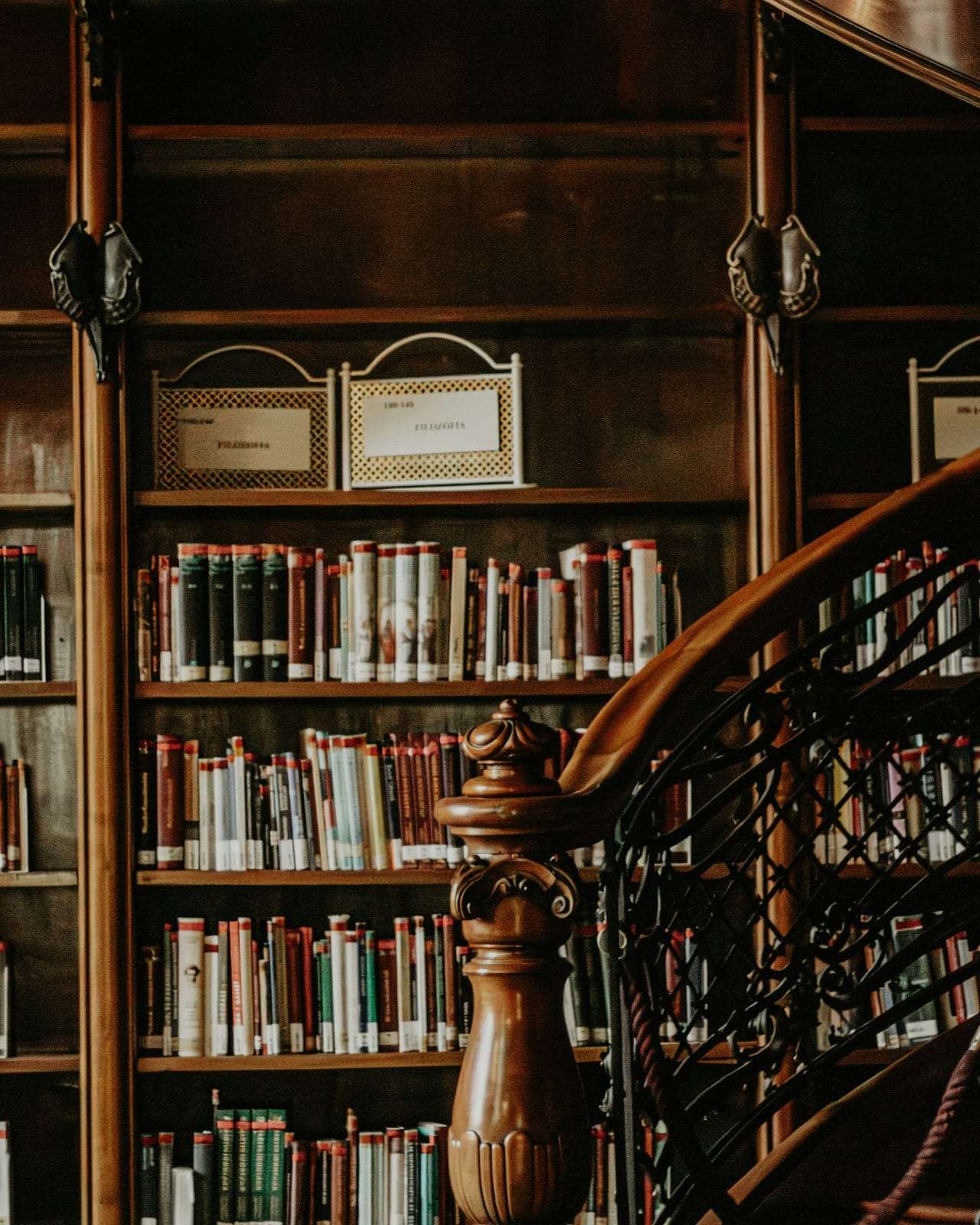 An old private library with a wooden staircase and shelves of bound books